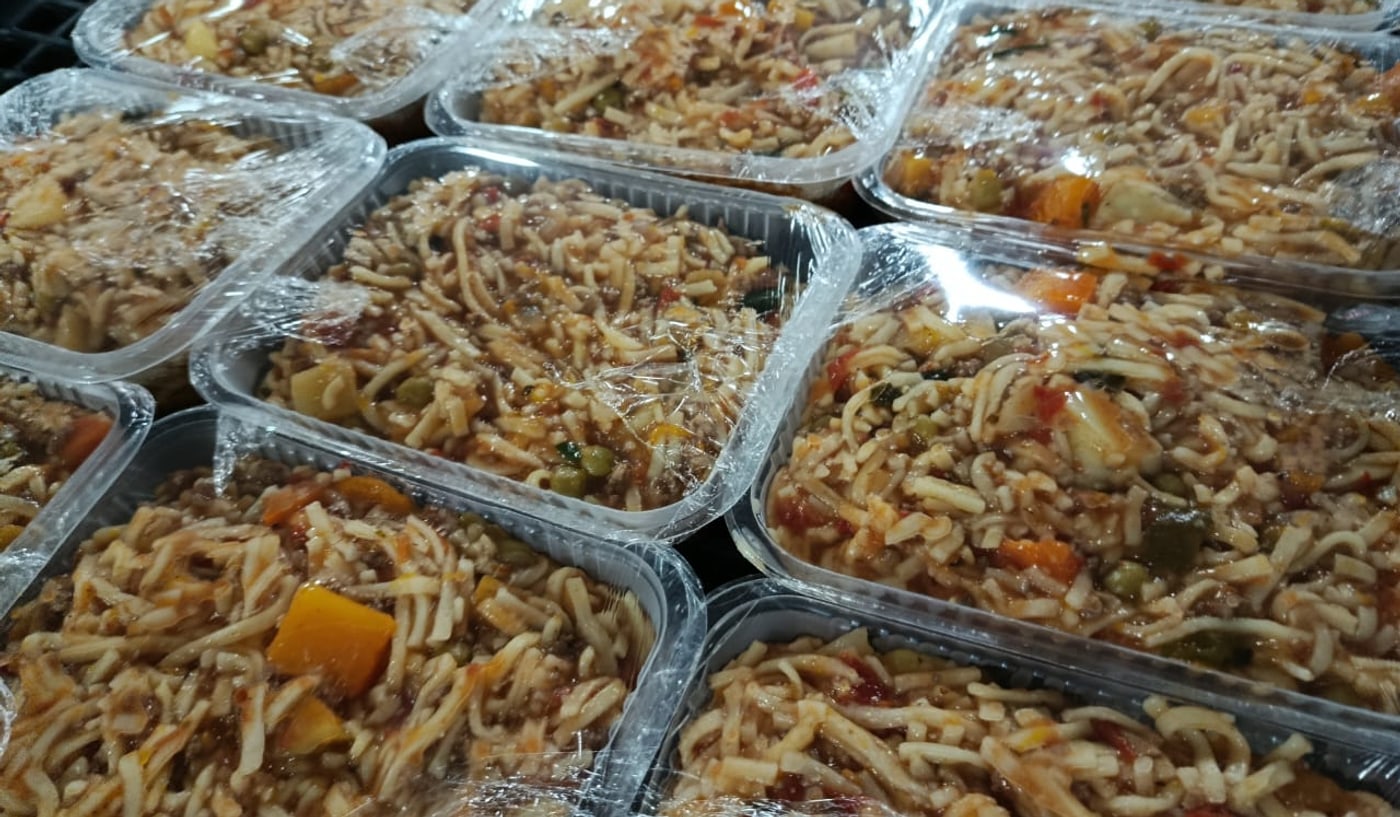 Viandas de comida preparadas y envueltas, listas para distribuir