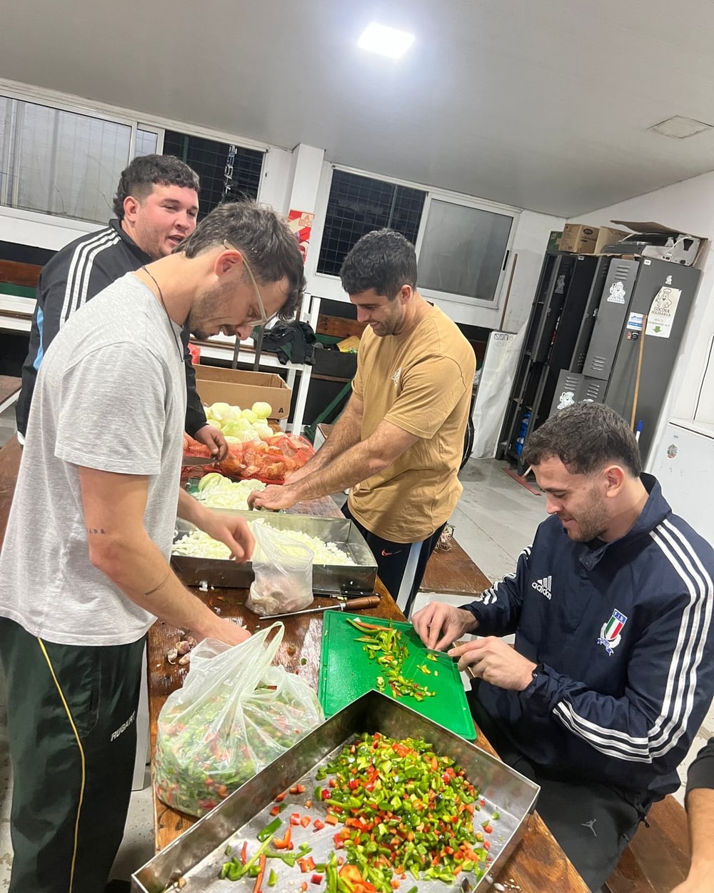 Voluntarios cortando cebollas y morrones en la cocina del club