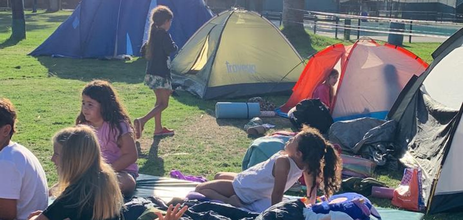 Chicos descansando entre las carpas del campamento de la colonia